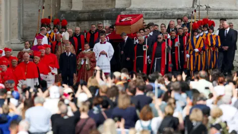 Reuters Pope Francis' body is carried in a coffin into Saint Peter's Basilica at the Vatican on the day of its translation, as seen from Rome, Italy, April 23, 2025.