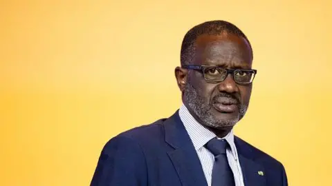 Getty Images Ivory Coast's main opposition leader Tidjane Thiam wearing a navy suit and tie with a white shirt and black spectacles