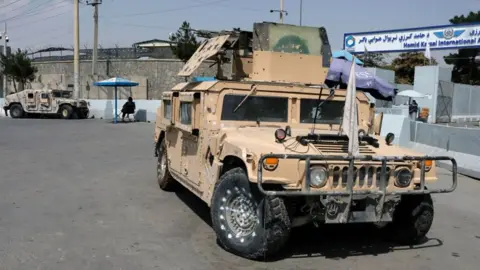 Getty Images Abandoned Humvee military trucks left behind by the US military, that fell into the hands of the Taliban, are seen outside the Hamid Karzai airport on 22 September 2021 in Kabul, Afghanistan.