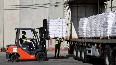 EPA Pallets of food aid are loaded on a lorry waiting to enter Gaza at the Kerem Shalom crossing, in southern Israel (22 May 2025)