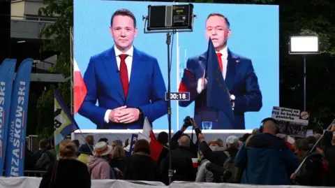 Reuters Supporters of Warsaw Mayor Rafal Trzaskowsk watch a final debate with Rafal Trzaskowski and Karol Nawrocki on 23 May