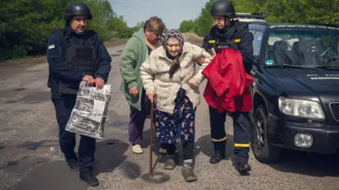 Emergency services of Sumy An elderly Sumy region resident is evacuated from her village with the help of two men