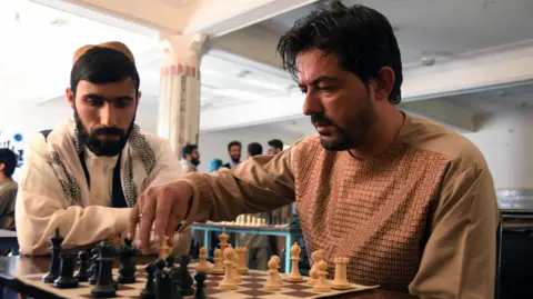 AFP via Getty Images A stock image of a man playing chess in a tournament in Kandahar in June 2022