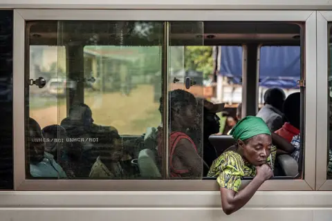 Getty Images A Congolese refugee looks out from the window of a bus