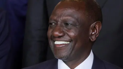 Reuters Kenya's President William Ruto in a black suit and white shirt