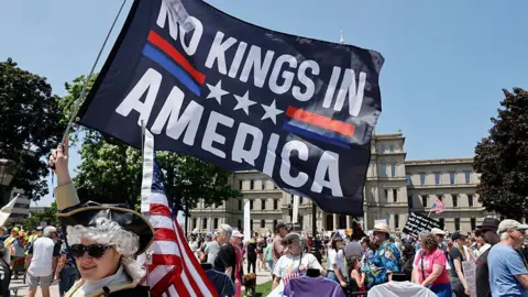 Getty Images People take part in a "No Kings" protest outside the Michigan Capitol in Lansing, Michigan, on 14 June 2025 as US President Donald Trump presides over a military parade in Washington, DC.