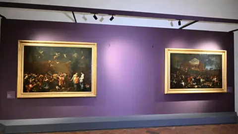 Claudio Giovannini/EPA-EFE/Shutterstock The wall of the Uffizi Gallery without the painting Portrait of Ferdinando de' Medici Grand Prince of Tuscany by Anton Domenico Gabbiani. Two large paintings remain on the purple wall with a gap between them.