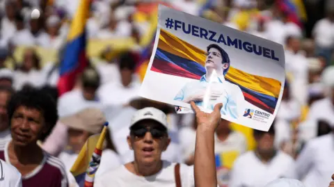 EPA A person holds up a sign with Miguel Uribe Turbay's face on it