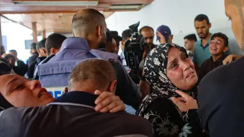 AFP Relatives mourn three Palestinian journalists who were among five people killed in an Israeli strike on the compound of al-Ahli hospital, in Gaza City, on 5 June 2025