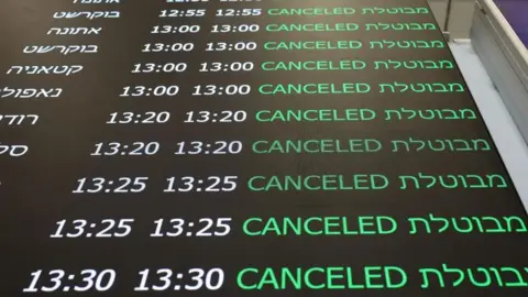 EPA A flight status display shows cancelled flights in the departure terminal at Ben Gurion Airport near Tel Aviv