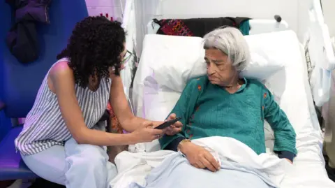 Free Alaa Sanaa Seif (L) sits beside her mother Laila Soueif (R) at St Thomas' hospital, London
