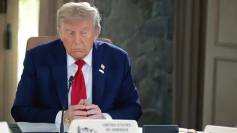 Getty Images Donald Trump at G7 meeting in Alberta, sat at a table, hands clasped, looking to the right
