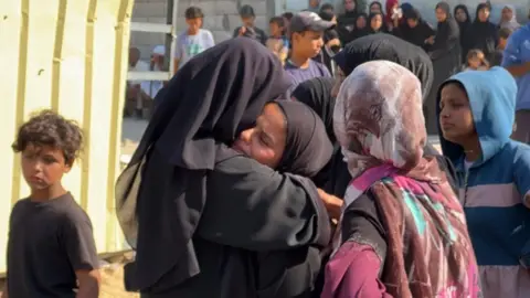 BBC Mary Sheikh al-Eid's family is comforted after her body is brought to Nasser Hospital in Khan Younis, southern Gaza (24 July 2025) 