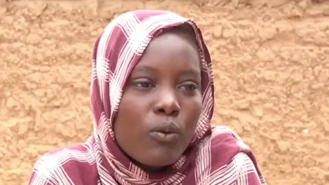 BBC Alawia Babiker Ahmed, with a headscarf, is seen talking in Sudan's Tawila town