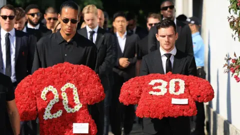 Reuters Liverpool players Virgil van Dijk (C) and Andy Robertson (R) carry floral tributes