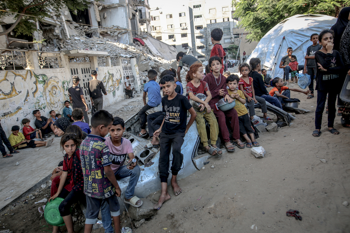 Palestinians carrying pans, gather to receive hot meals, distributed by a charity organization in Gaza City, where residents are struggling to access food due to the ongoing Israeli blockade and attacks in Gaza City, Gaza on July 23, 2025. [Saeed M. M. T. Jaras - Anadolu Agency]