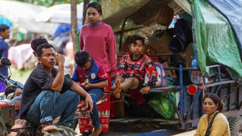 Reuters People, evacuating from Pong Tuek village, in Banthey Empel district, around 20 km (12 miles) from the disputed Ta Moan Thom temple, rest at a temporary shelter