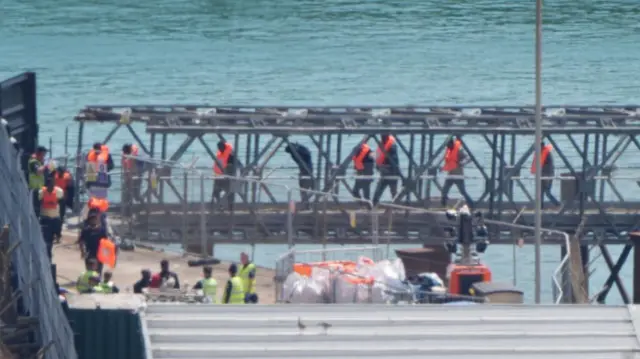 A group of people thought to be migrants are escorted from a Border Force vessel at Dover on 10 July 2025