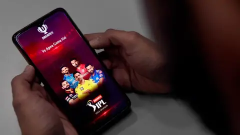 AFP via Getty Images In this photo illustration, a user (not in picture) checks the Dream11 application of the Indian Premier League (IPL) cricket tournament, on his mobile phone in New Delhi. 