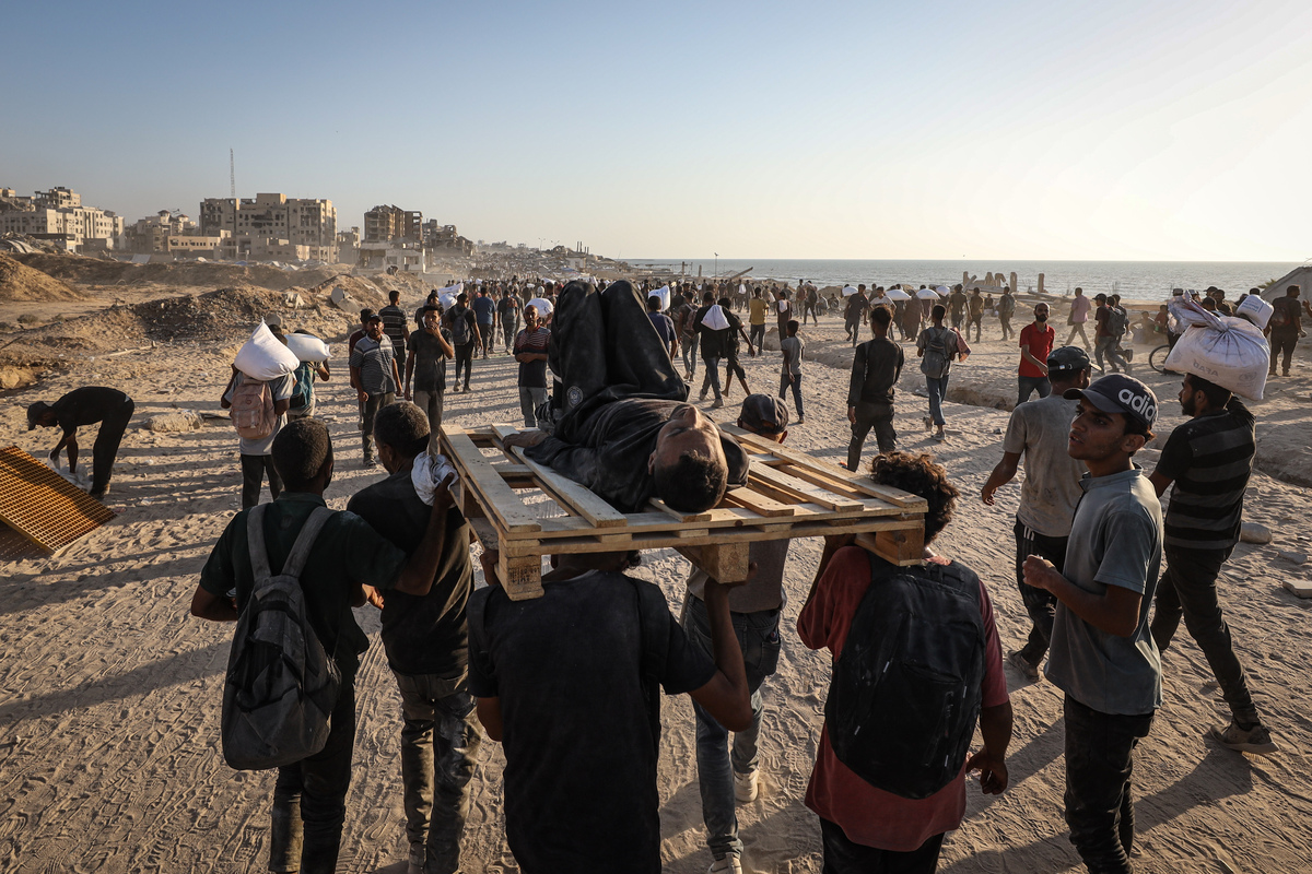 Palestinians carry the bodies of Palestinians killed by Israeli forces as they opened fire on crowd waiting for humanitarian aid in the Zikim area in northern Gaza, on August 03, 2025. [Khames Alrefi - Anadolu Agency]