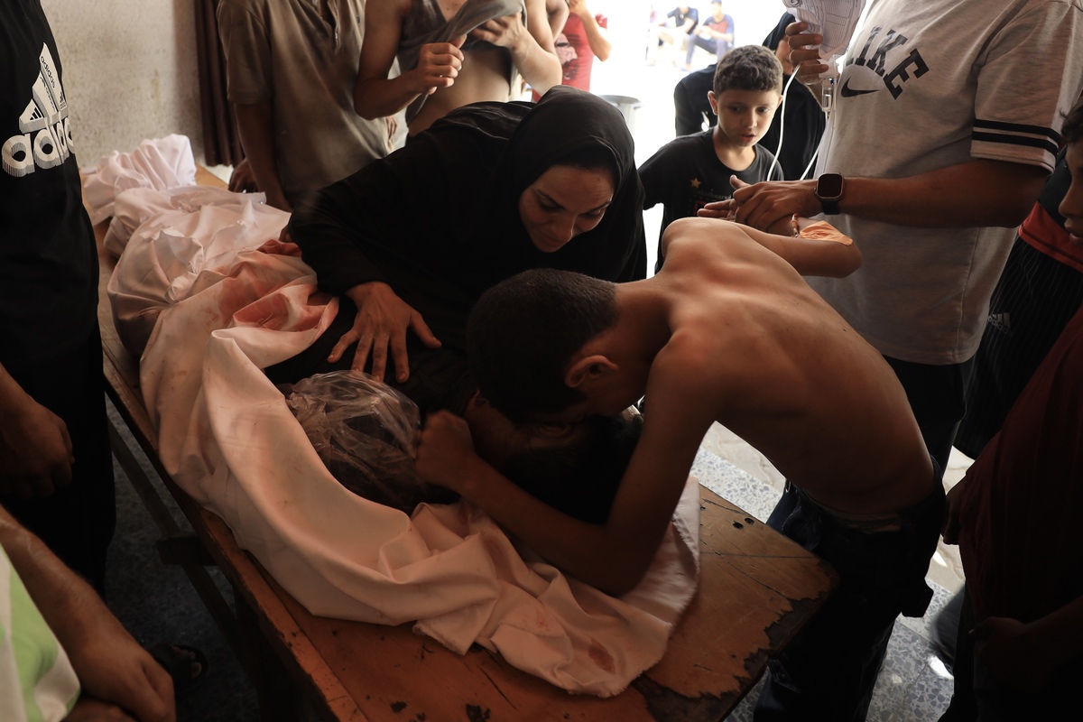 Relatives mourn near the body of Palestinian killed in an Israeli attack on a house on Al Thalatheni Street to Al-Ahli (Baptist) Hospital during funeral procedures in Gaza City, Gaza on August 14, 2025. [Khames Alrefi - Anadolu Agency]