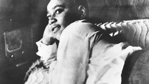 Getty Images A black and white file photo showing Emmett Till lying on his bed