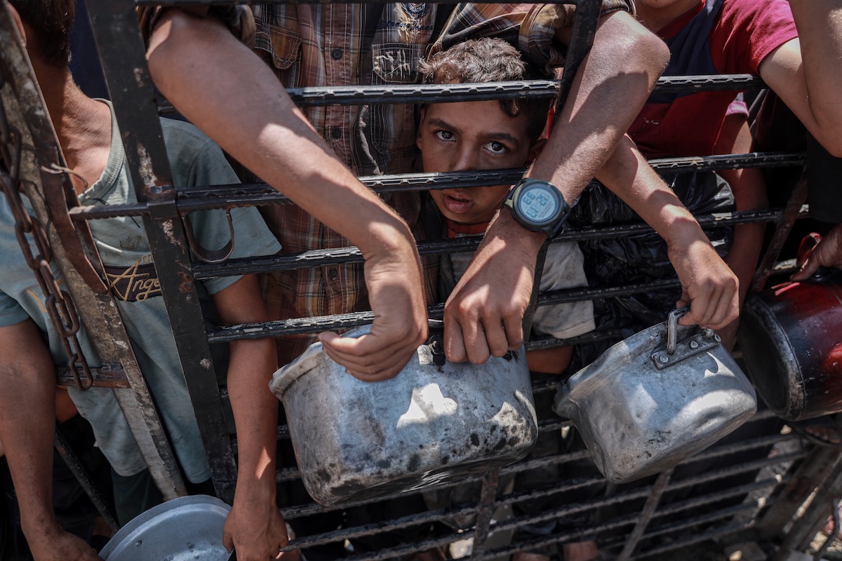 Palestinians carry pans and bowls forms a crowd to receive food aid provided by charity organization in Gaza City, Gaza on September 2, 2025. [Abdalhkem Abu Riash - Anadolu Agency]