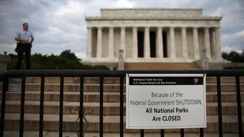 Getty Images Park Police officer stand guard in front of the closed Lincoln Memorial. A sign reads: "Because of the federal government shutdown, all national parks are closed."