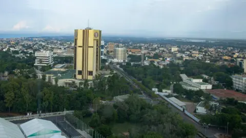 Photothek via Getty Images A city view of Lome, showing one tall building at the centre towering over other smaller buildings stretching to the horizon