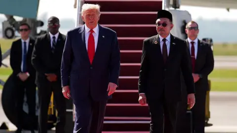 Getty Images US President Donald Trump is greeted by Malaysian Prime Minister Anwar Ibrahim as he arrives at Kuala Lumpur International Airport on October 26, 2025.