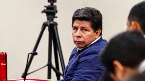 EPA/Shutterstock Pedro Castillo, wearing a blue jacket, has a serious expression as he is handed his sentence handed down by the court that tried him for the failed coup attempt in 2022.