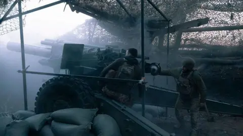 Marharyta Fal/Frontliner/Getty Images Ukrainian artillerymen fire a gun in a foggy sky underneath netting near Pokrovsk