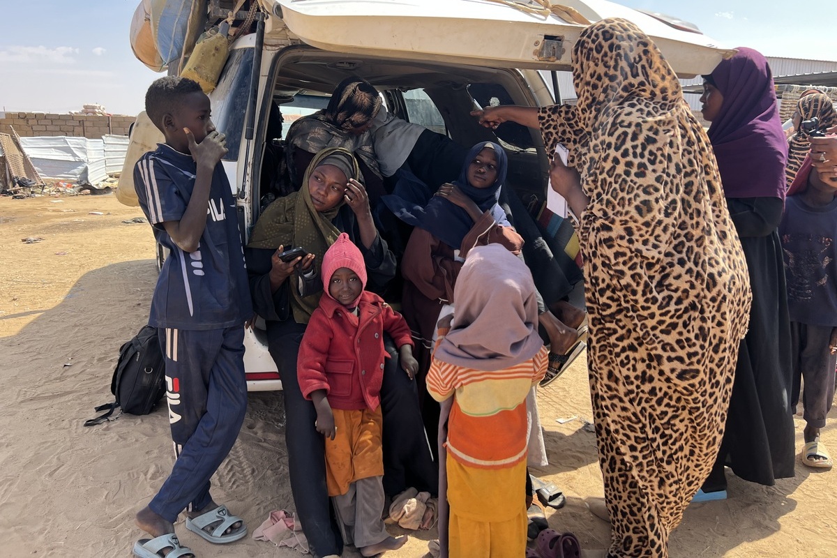 Displaced Sudanese families who fled the recent clashes in North Darfur’s capital El-Fasher and nearby villages gather around vehicles after arriving in Al Dabbah town of Sudan’s Northern State, where they continue to live under difficult conditions, in Al Dabbah, Sudan, on November 3, 2025. [Stringer - Anadolu Agency]