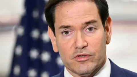 AFP via Getty Images US Secretary of State Marco Rubio speaks to traveling journalists at an airport in Canada on 12 November after the G7 foreign ministers meeting. 