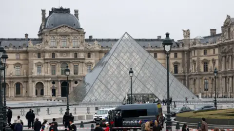 Reuters Police guard near the pyramid of the Louvre museum in Paris after a jewellery heist robbery. Photo: 19 October 2025