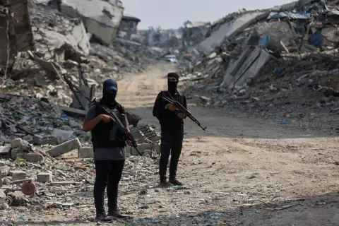 AFP Hamas fighters guard an area of Gaza City where they are searching for the bodies of hostages with the help of the International Committee of the Red Cross (ICRC), in northern Gaza (3 November 2025)