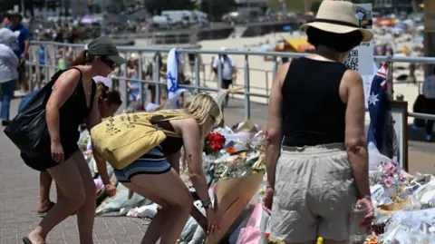 EPA People continue to bring flowers to the Bondi Beach promenade
