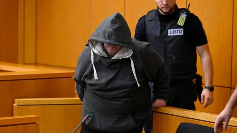 Getty Images The defendant Fernando P. is escorted by a justice officer at the regional court to hear the verdict in the case where he is accused of drugging and raping his wife in Aachen, western Germany, December 19, 2025.
