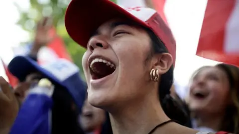 Reuters A happy young woman shouting in a crowd.