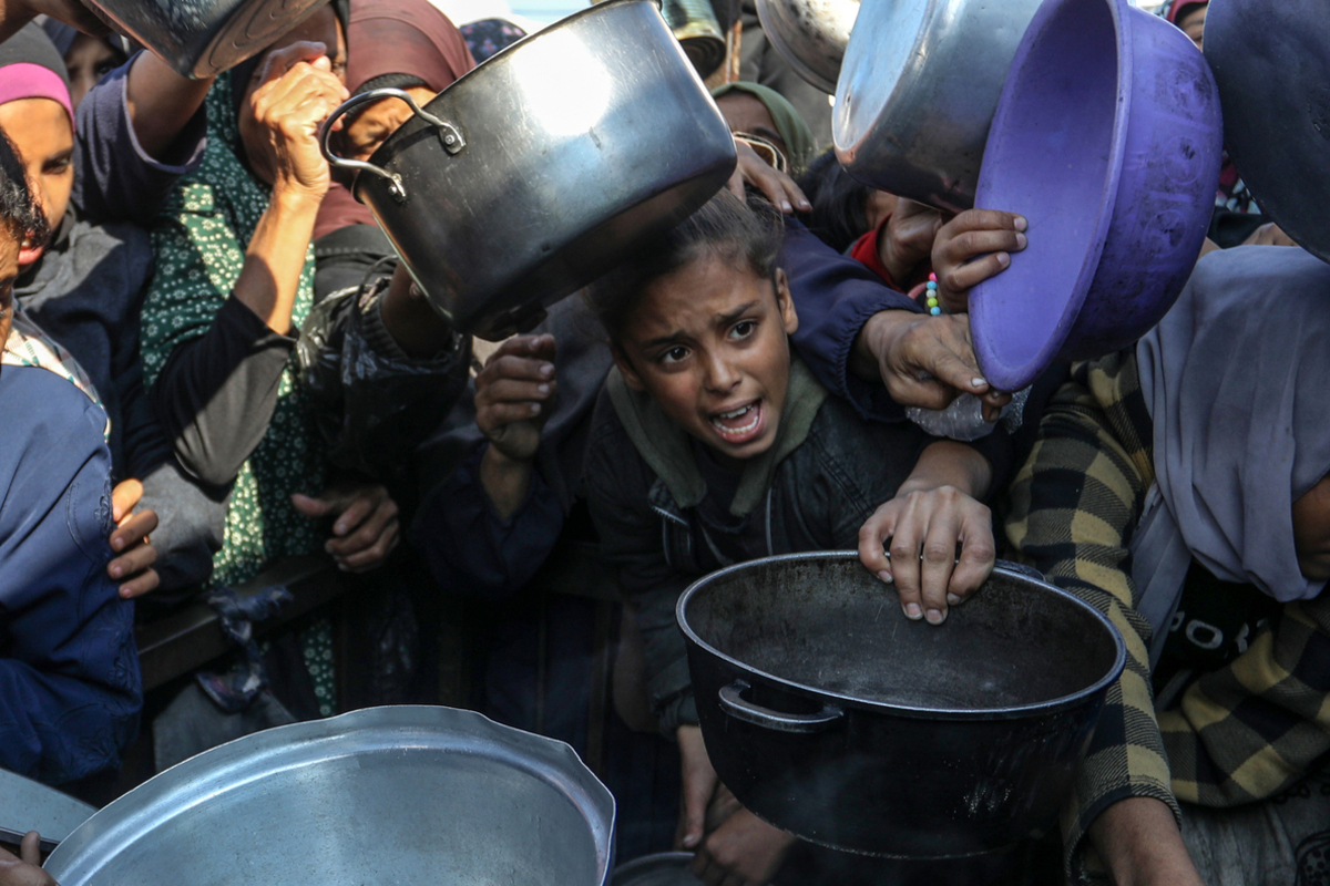 Displaced Palestinians, who struggle with hunger, wait to receive hot meal, distributed by charity organizations, in al-Mawasi region of Khan Yunis, Gaza on December 17, 2025. [Abed Rahim Khatib - Anadolu Agency]