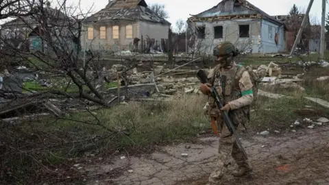 Reuters A Ukrainian soldier carrying a gun on patrol in Donetsk 