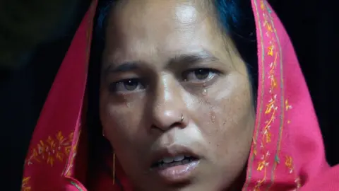Rubaiyat Biswas/BBC Sunali Khatun looks at the camera as tears run down her cheek.