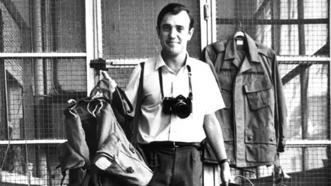 AP Photo/File Peter Arnett stands with gear that he carries out in field while covering the Vietnamese army 1963, in Saigon, Vietnam