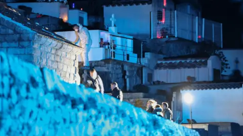 Pascal POCHARD-CASABIANCA/AFP Forensic specialists look for evidence in a cemetery in Corsica in the dark on 12 January