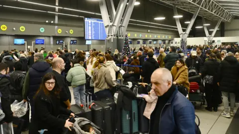 Getty Images Passengers wait at the Thessaloniki Airport "Makedonia" amidst disruption in flights across Greece linked to a technical problem